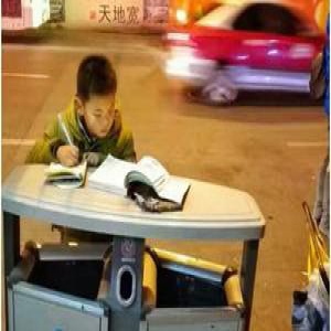 青岛8岁男孩寒夜趴垃圾桶上写作业(图)