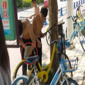 三男子石头猛砸共享单车锁 开锁后骑着扬长而去